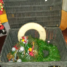 Witte krans met kunstbloemen in een grijze rieten mand
