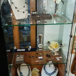 Vitrinekasten met diverse tweedehands artikelen: sieraden, decoratieve objecten en huishoudartikelen
