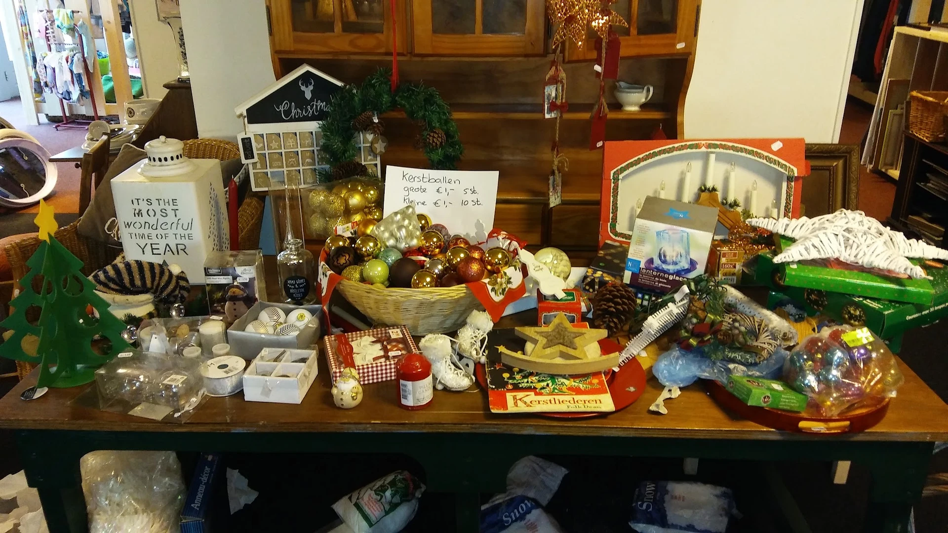 Uitgestalde kerstdecoratie en seizoensartikelen op een tafel in de winkel