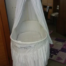 Witte babybed of wieg met gaas/muggennet en een prijskaartje