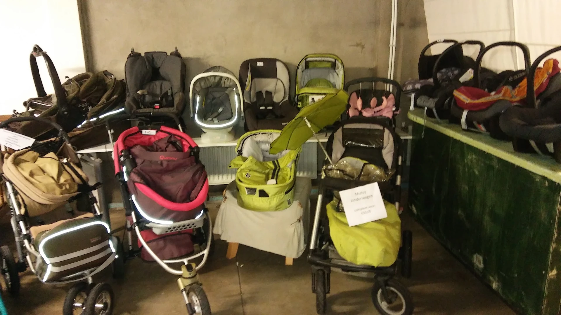 Verzameling kinderwagens en buggy's in verschillende kleuren opgesteld in de winkel