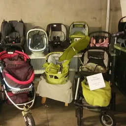 Verzameling kinderwagens en buggy's in verschillende kleuren opgesteld in de winkel