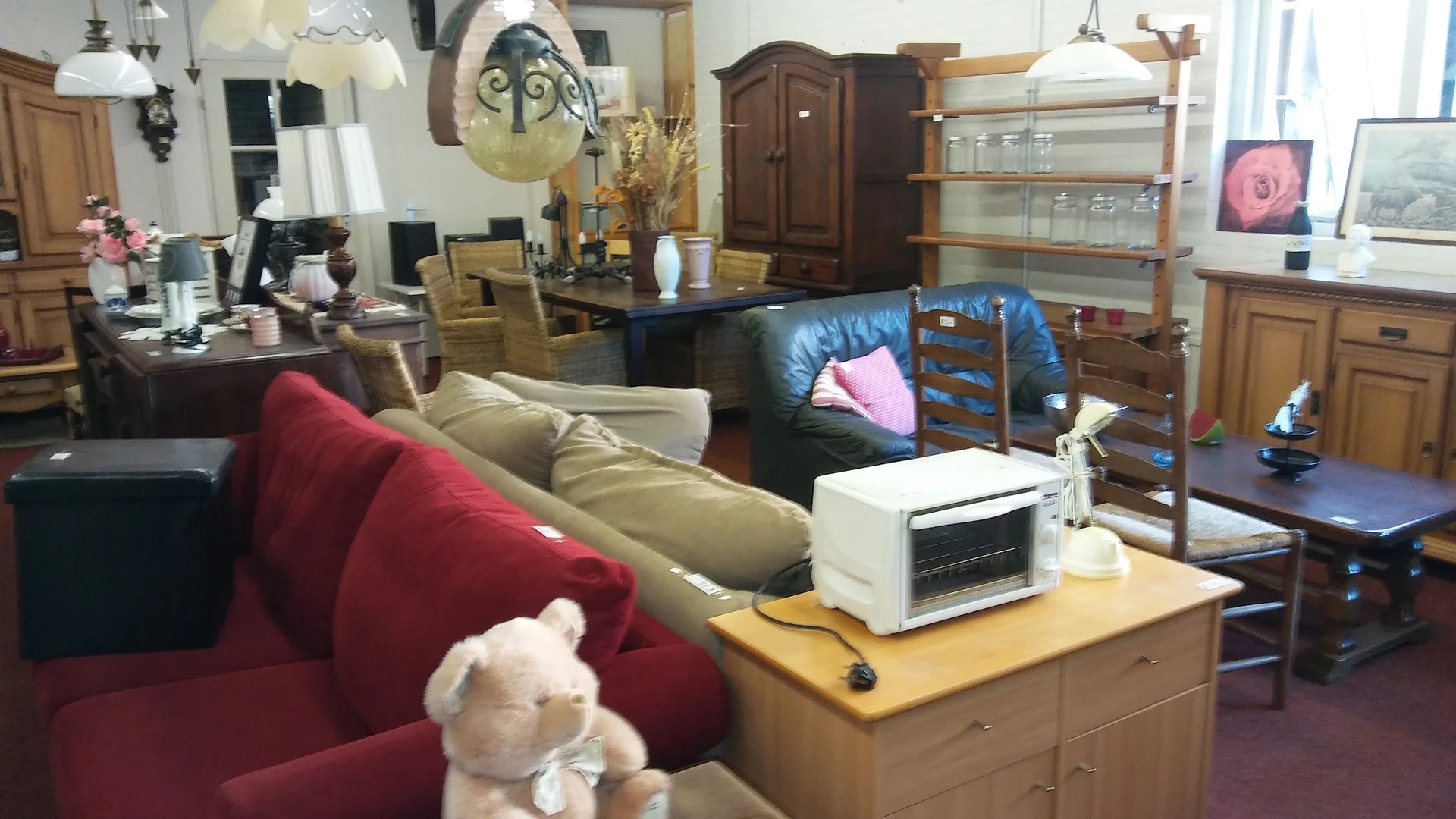 Overzicht van kringloopwinkelinterieur met meubels, huishoudelijke spullen en decoraties uitgestald