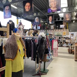 Winkelvloer met kledingrekken, etalagepoppen en portretfoto's aan het plafond