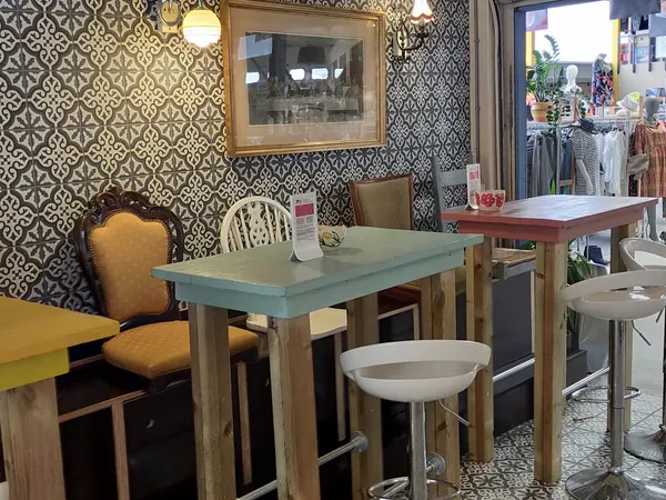 Ingerichte eethoek met tafel, stoelen en behang in kringloopwinkel