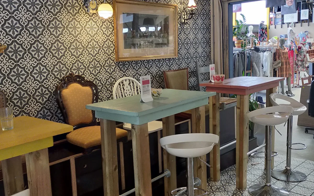 Ingerichte eethoek met tafel, stoelen en behang in kringloopwinkel