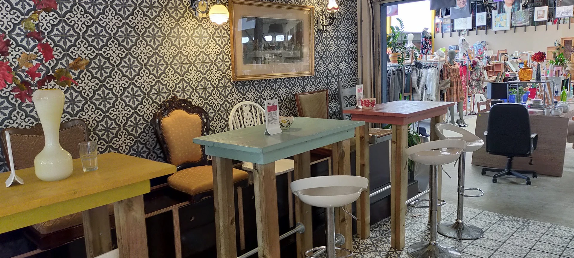 Ingerichte eethoek met tafel, stoelen en behang in kringloopwinkel