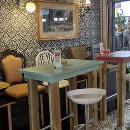 Ingerichte eethoek met tafel, stoelen en behang in kringloopwinkel