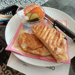 Bord met twee wafels en een kommetje met augurken en tomatensaus op een wit bord