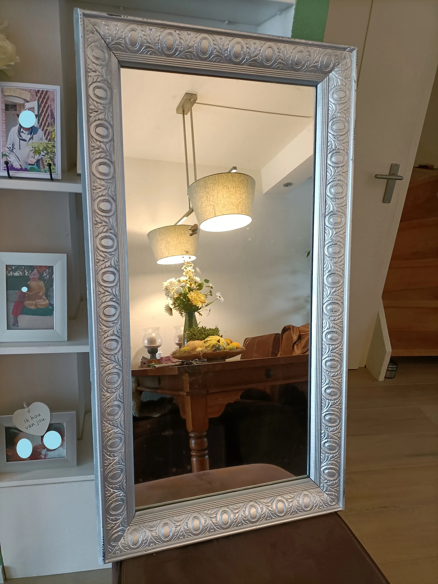 Twee hangende textielampen boven een houten tafel met bloemen in een vaas
