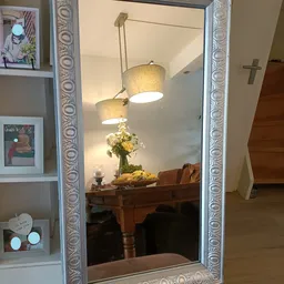 Twee hangende textielampen boven een houten tafel met bloemen in een vaas