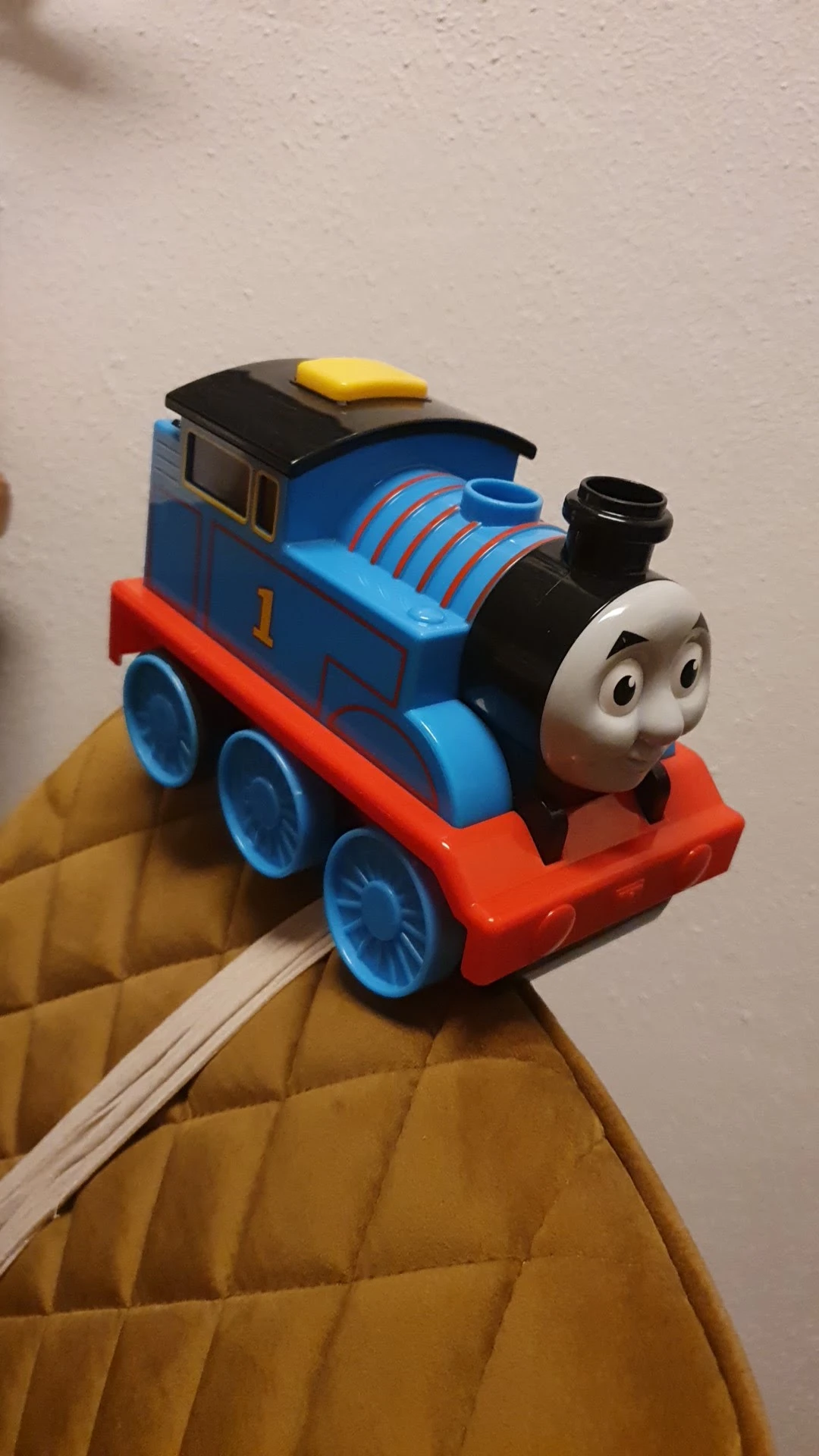 Blauwe speelgoedtrein Thomas met rood onderstel en zwarte schoorsteen in close-up