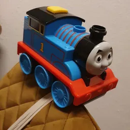 Blauwe speelgoedtrein Thomas met rood onderstel en zwarte schoorsteen in close-up