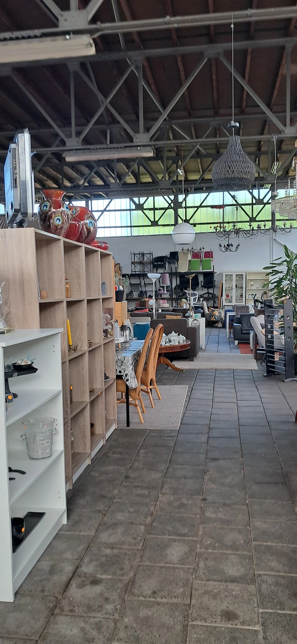 Overzicht van de winkelvloer met houten stellingen, houten stoelen, tafels en diverse inrichting en meubelen