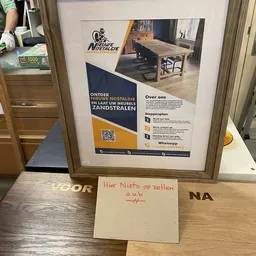 Advertentieposter met merklogo, foto's van meubelen en QR-code op winkelmuur