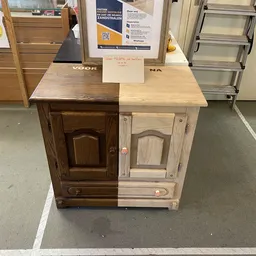 Houten kastje met twee deuren, half donker en half licht gelakt, met een notitiepapier op het blad