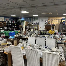 Winkelvloer vol met huishoudelijke spullen, meubels en dozen in een kringloopwinkel