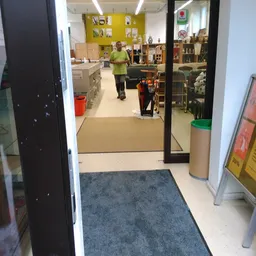 Ingang en winkelvloer van een kringloopwinkel met stellingen en spullen