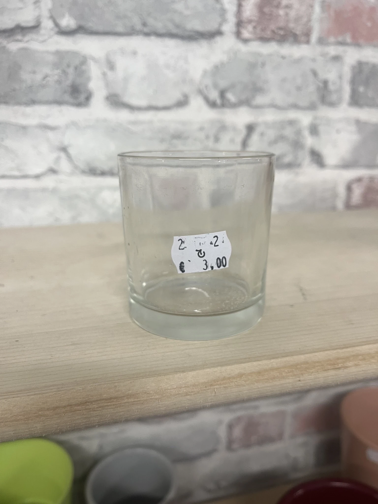 Glazen beker met prijskaartje waarop '2 € 2 € 3,00' staat geschreven