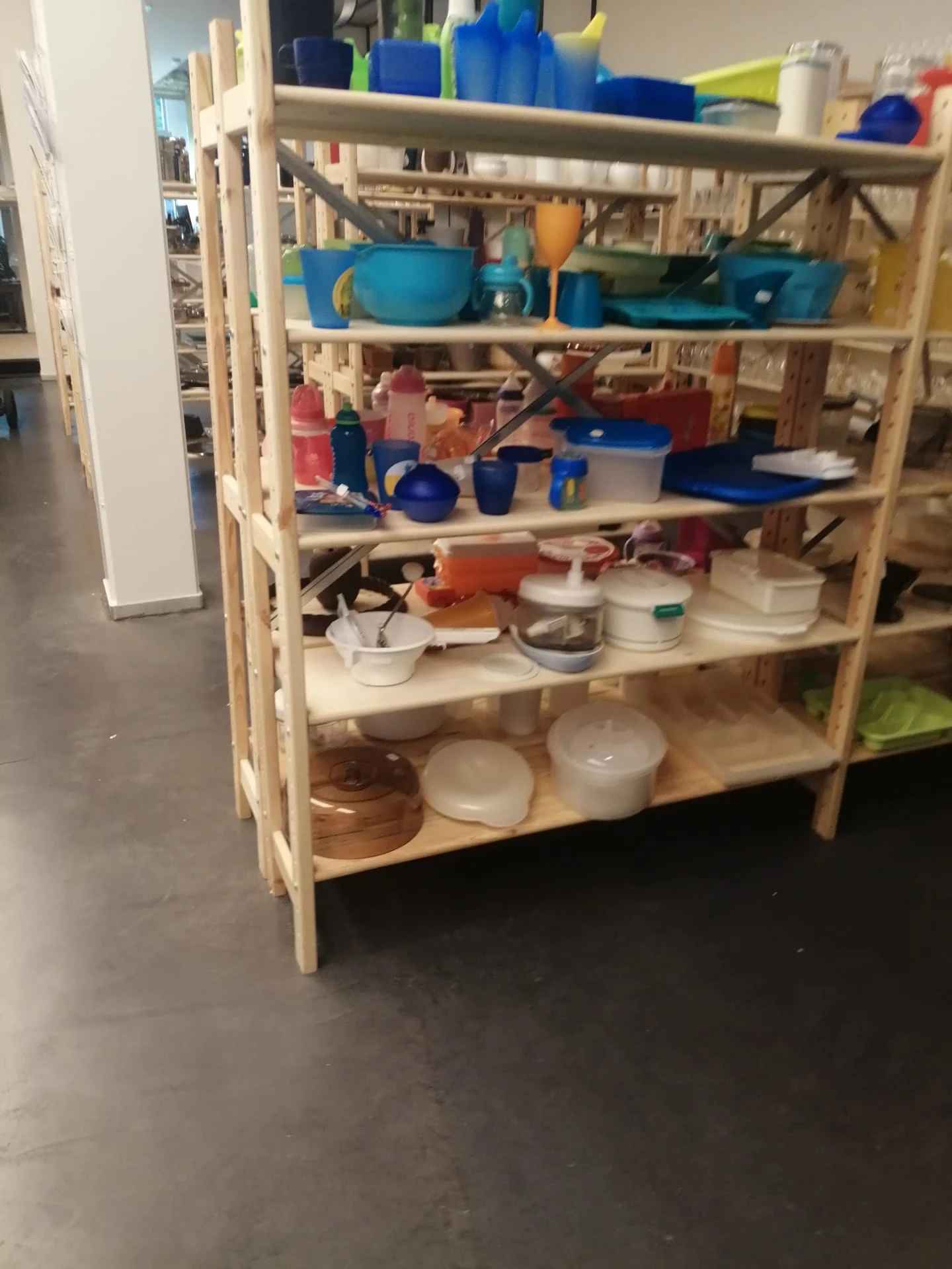 Houten stellingkast met diverse huishoudelijke artikelen en keukenspullen