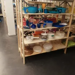 Houten stellingkast met diverse huishoudelijke artikelen en keukenspullen