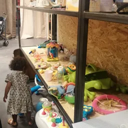 Kinderspeelgoed en zandkasteel in een zandtafel in de kringloopwinkel