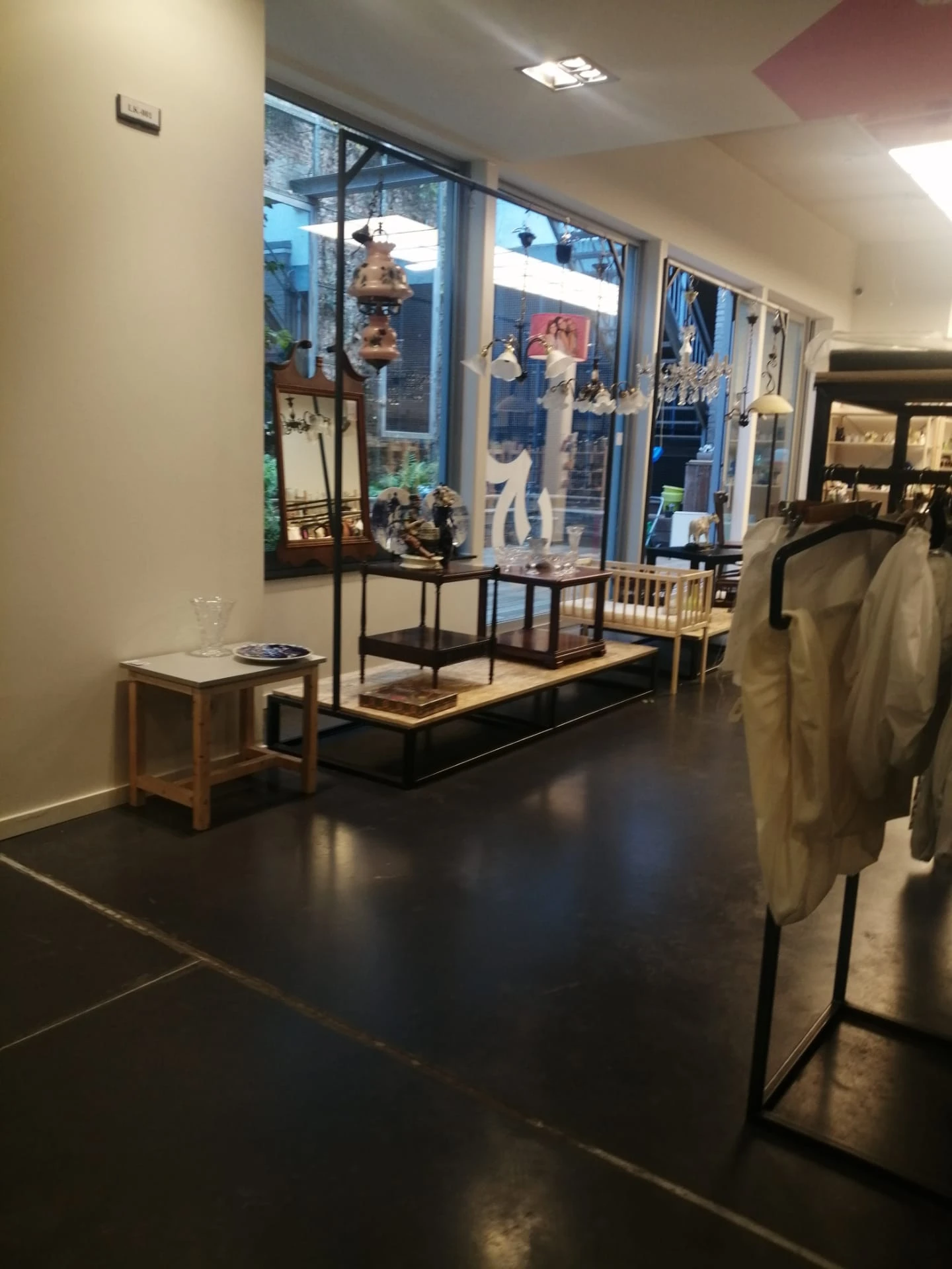 Museale vitrinekast met beeldjes en decoratie op voetstuk in winkelinterieur met donkere vloer
