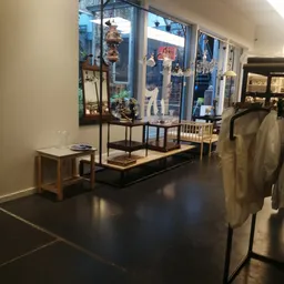 Museale vitrinekast met beeldjes en decoratie op voetstuk in winkelinterieur met donkere vloer