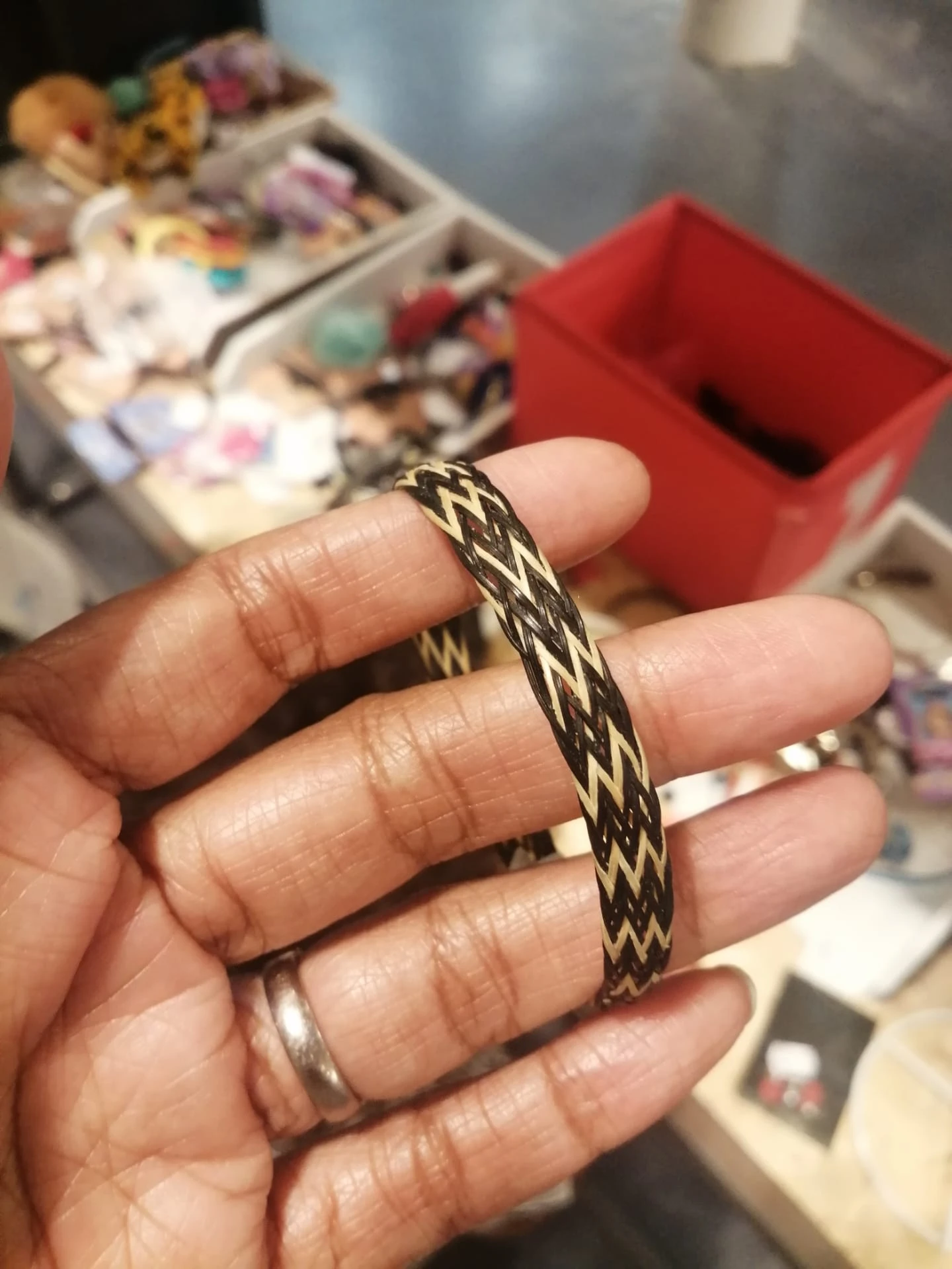 Close-up van een goudkleurige armband met gevlochten patroon om iemands pols