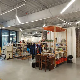 Ruim winkelbinnenruim met stellingen, kledingrekken, meubilair en diverse tweedehands artikelen
