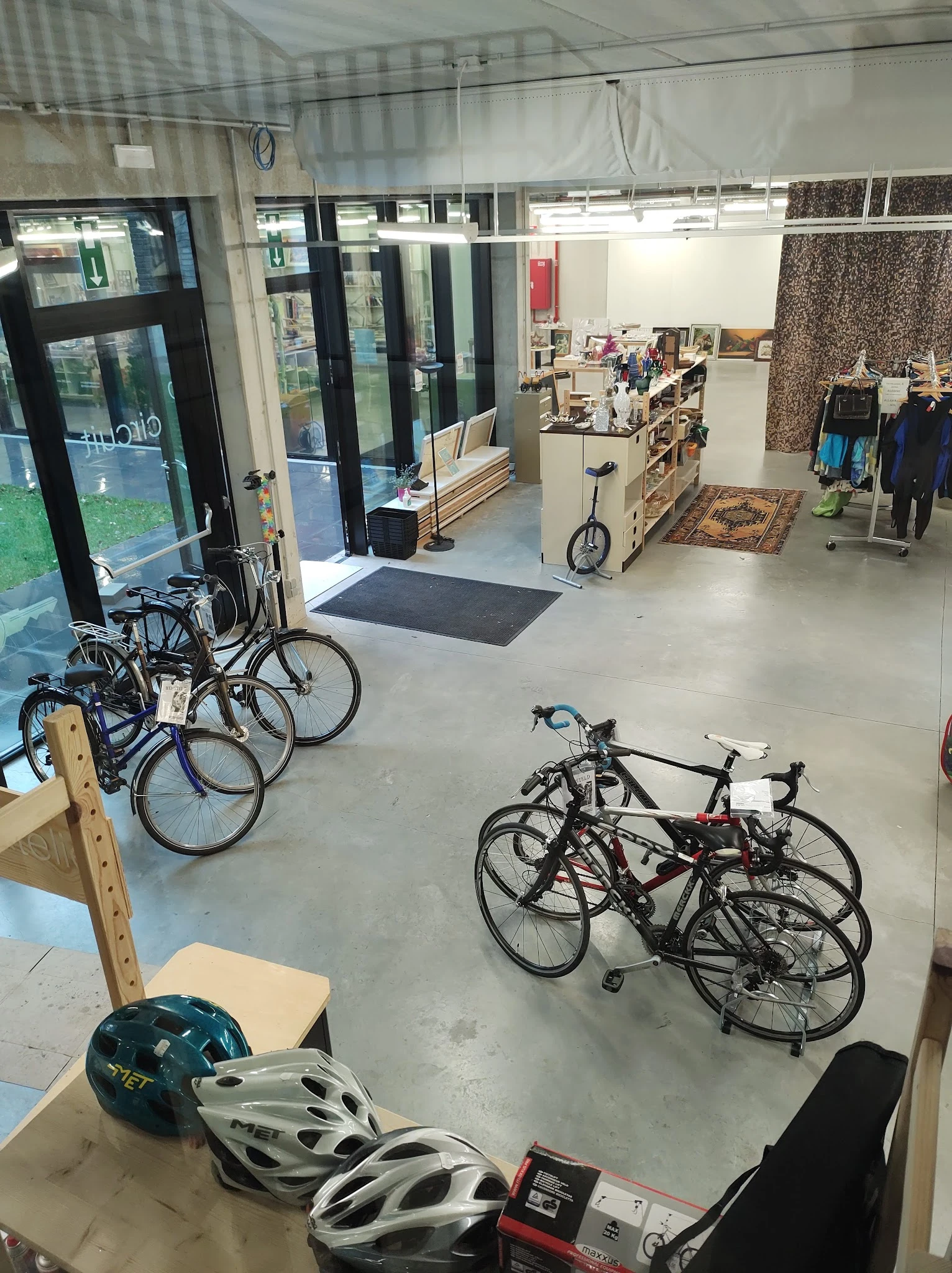 Winkelvloer met uitgestalde fietsen bij de ingang en stellingen met spullen op de achtergrond