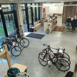 Winkelvloer met uitgestalde fietsen bij de ingang en stellingen met spullen op de achtergrond