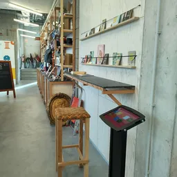 Winkelinterieur met houten werkbank, kruk, boekenplank en displaystandaard met kleurrijke tegels