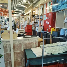 Winkelvloer met stellingen, toonbanken en uitgestalde spullen in een kringloopwinkel