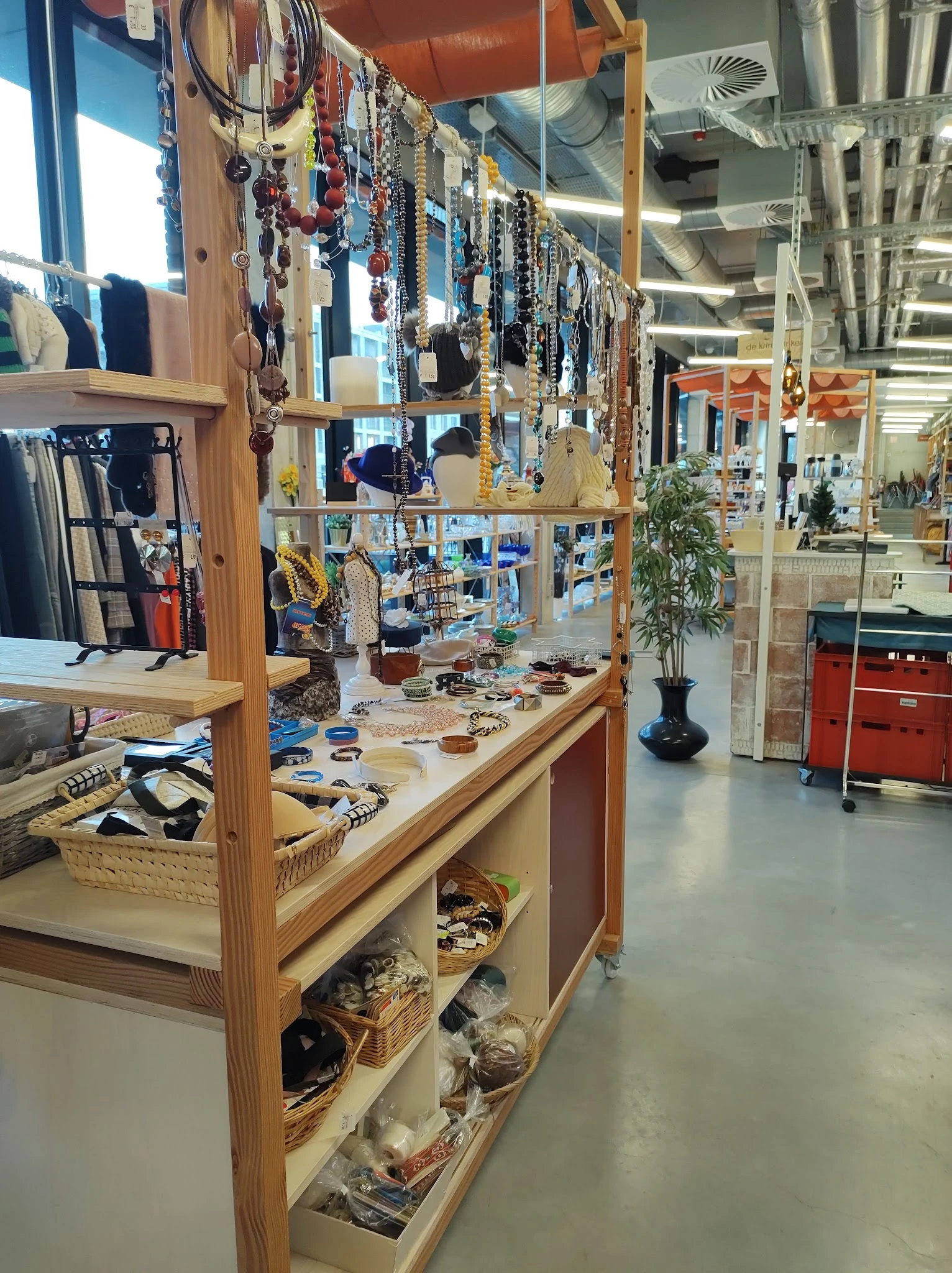 Houten displaykast met sieraden, accessoires en decoratieve artikelen uitgestald op verschillende niveaus