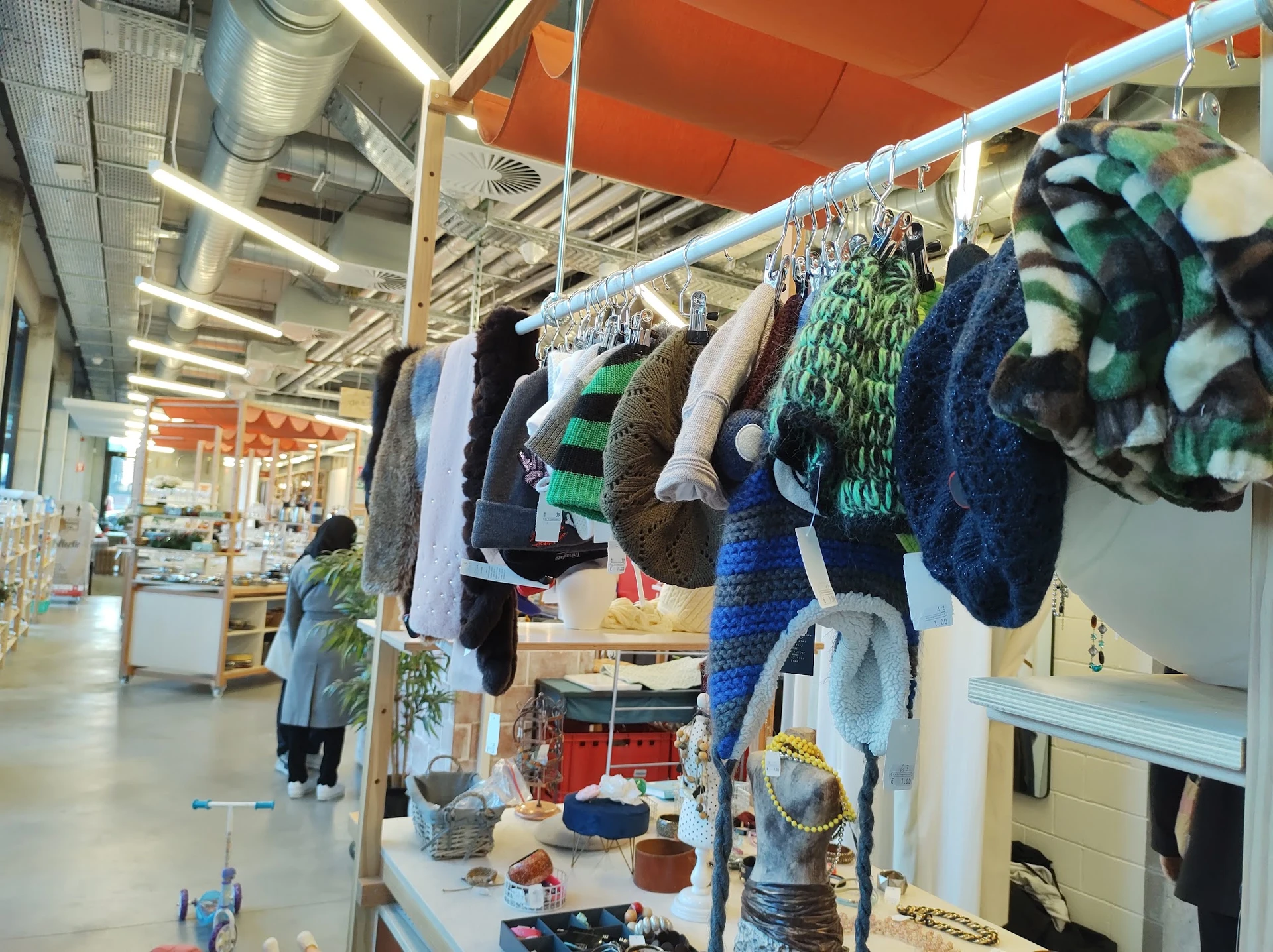 Rekken met tweedehands kleding en textiel opgehangen aan drooglijnen in de winkel