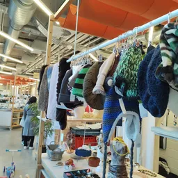 Rekken met tweedehands kleding en textiel opgehangen aan drooglijnen in de winkel