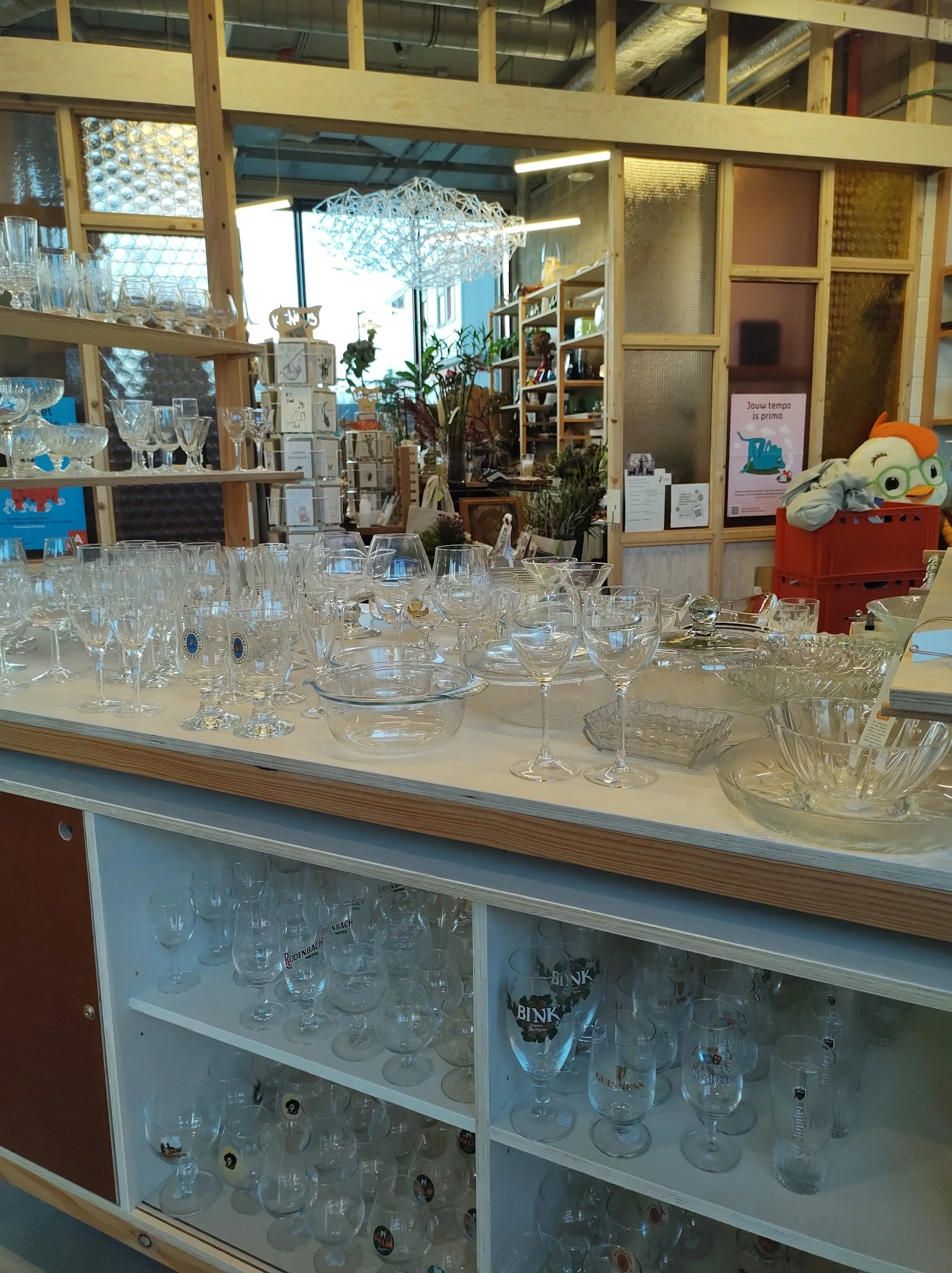 Grote verzameling kristalwerk en glazen servies uitgestald op een toonbank in de winkel