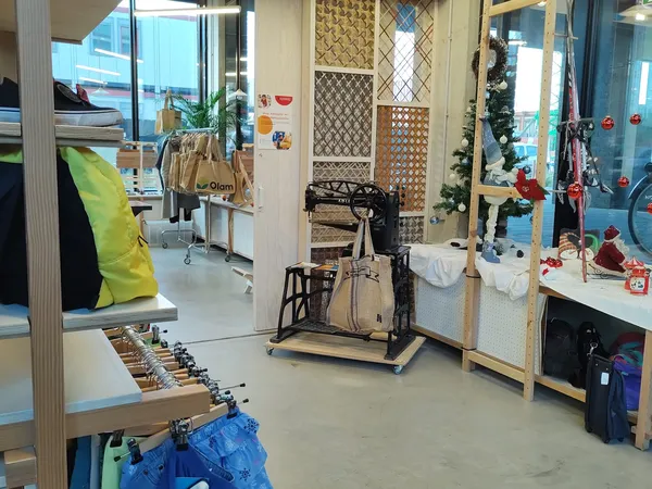 Winkelvloer van kringloopwinkel met kleding aan rekken, fietsen, sportapparatuur en diverse tweedehands spullen