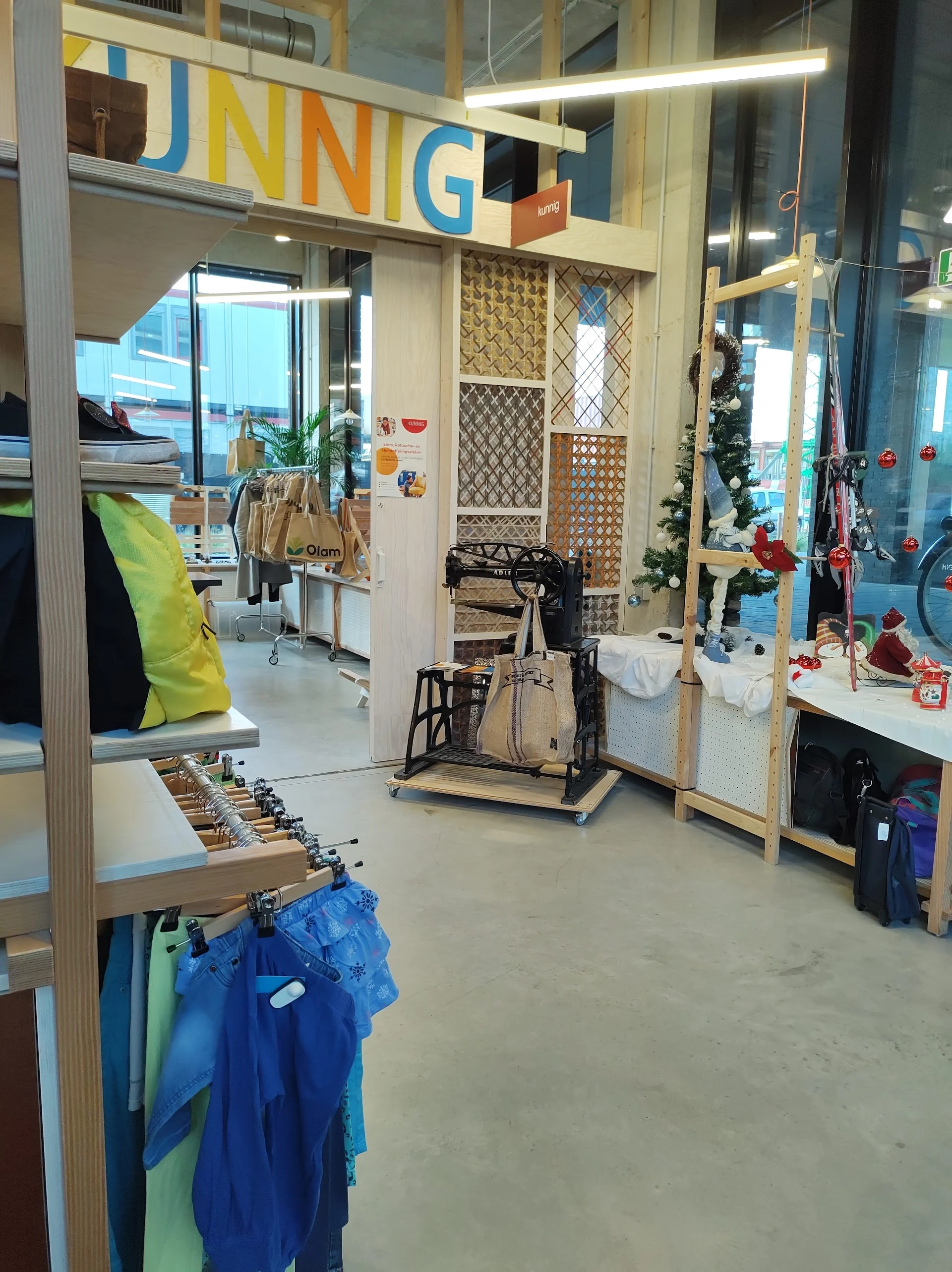Winkelvloer van kringloopwinkel met kleding aan rekken, fietsen, sportapparatuur en diverse tweedehands spullen