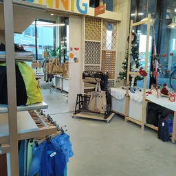 Winkelvloer van kringloopwinkel met kleding aan rekken, fietsen, sportapparatuur en diverse tweedehands spullen