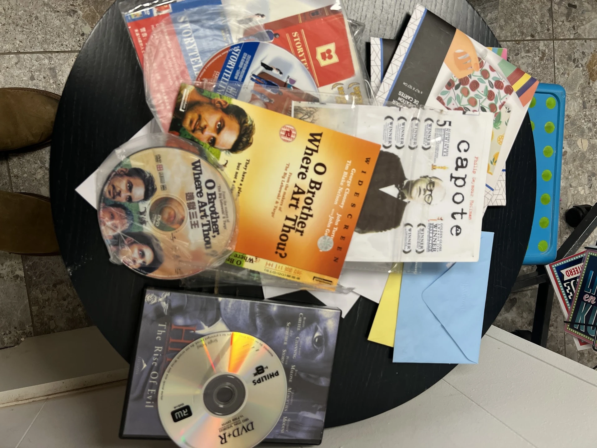 Assortiment tweedehands boeken, dvd's en ander media op zwarte tafel