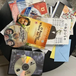 Assortiment tweedehands boeken, dvd's en ander media op zwarte tafel