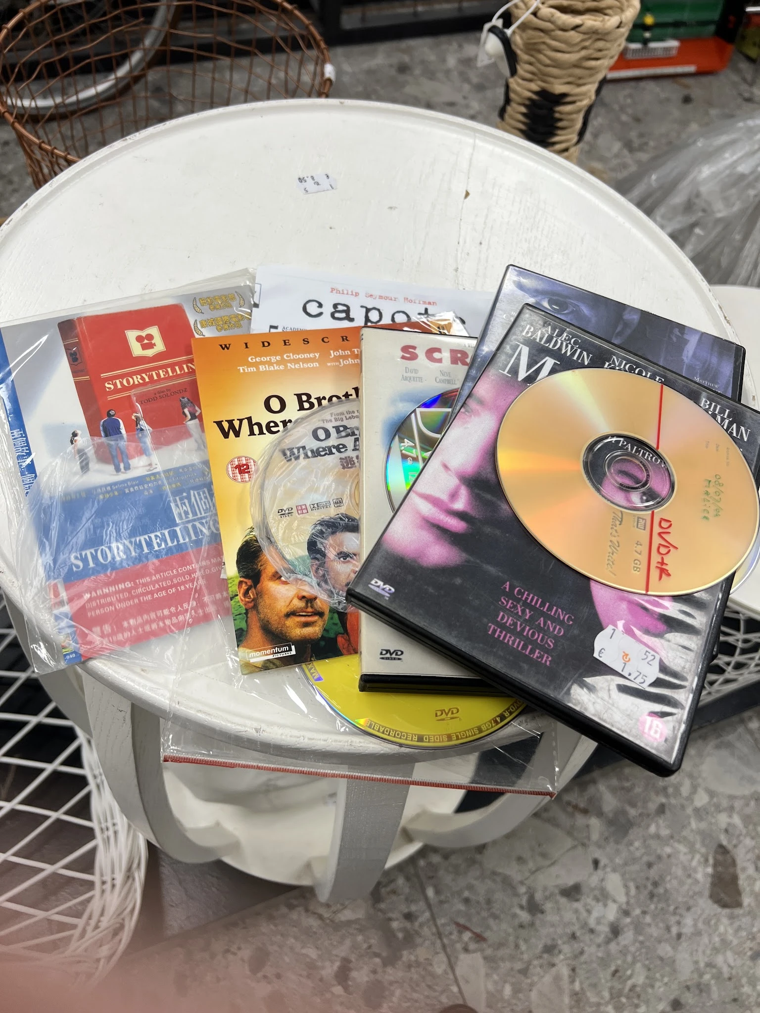 Verzameling dvd's en films op een tafel, waaronder titels als 'Storytelling', 'O Brother', 'Capote' en 'The Darwin Project'