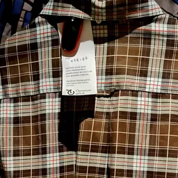 Tweedehands geruite kledingstukken met prijskaartje van €16,00