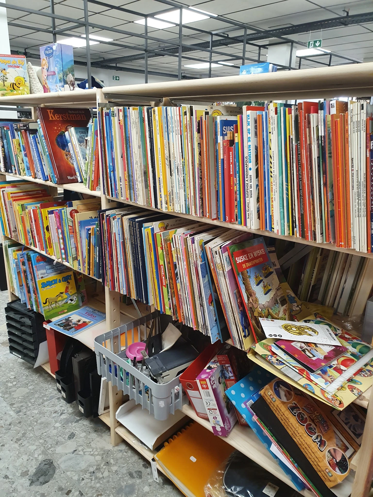 Rekken en stellingen vol met cd's, dvd's en andere media in verschillende kleuren en formaten