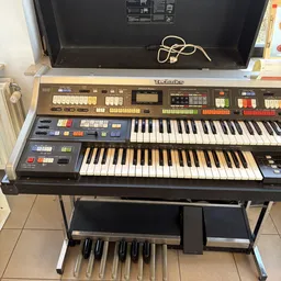 Tweedehands Technics elektronisch orgel met twee manualen en voetpedaal op standaard