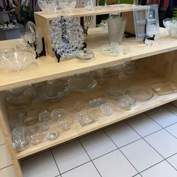 Glazen serviesgoed en schalen op planken in de winkel