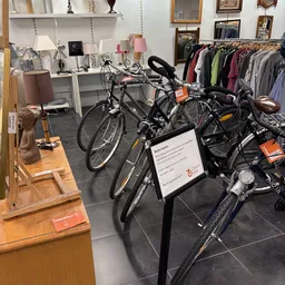 Verschillende tweedehands fietsen en e-bikes uitgestald in de winkel, met prijskaartjes eraan