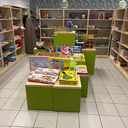 Groen display met uitgestalde speelgoed, puzzels en boeken in een kringloopwinkel